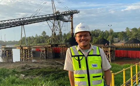 Dhany dengan helm & rompi keselamatan di area pelabuhan batu bara ITM